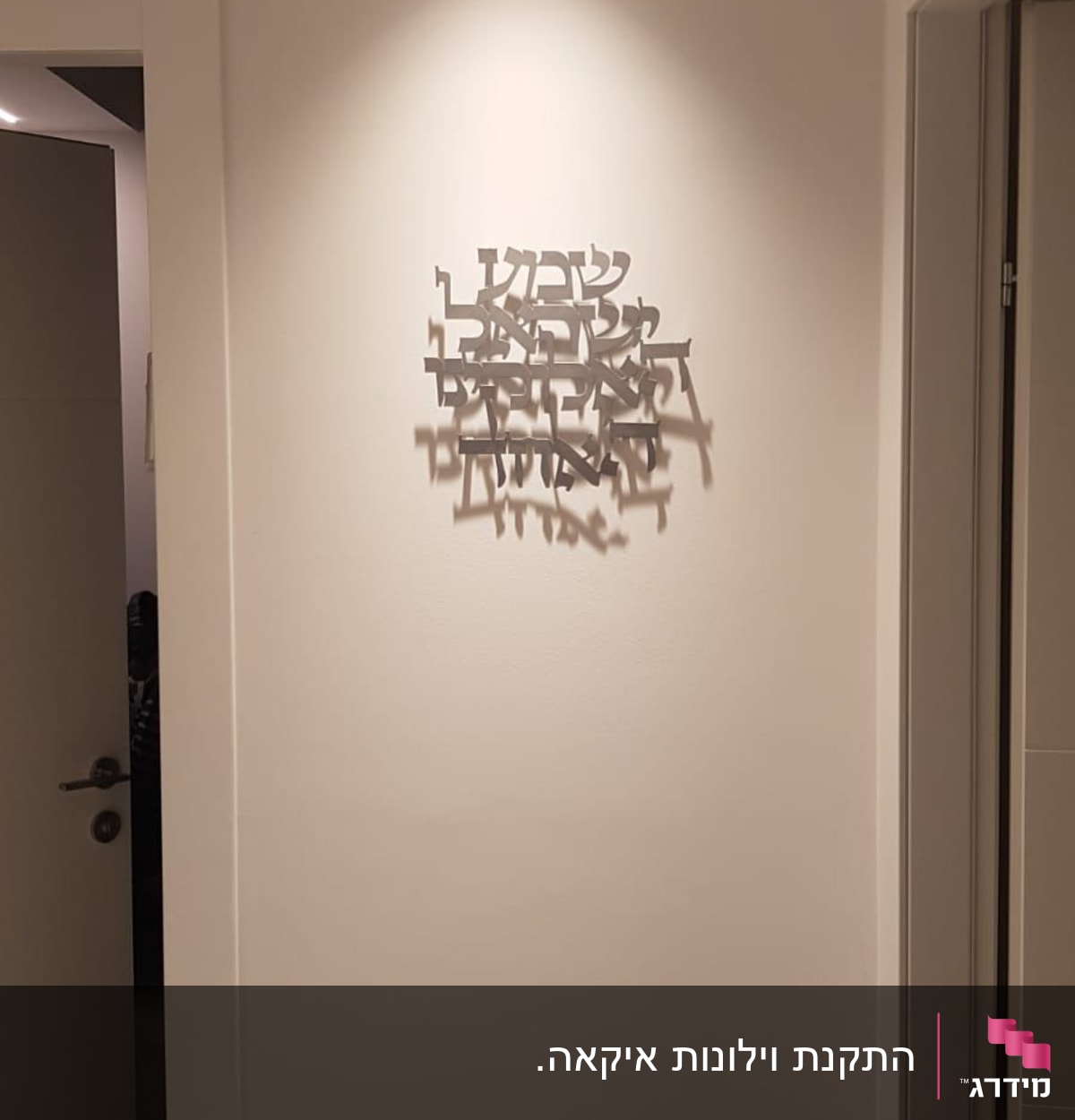 קיר עם שלט מתכת בעברית מואר בתאורה עליונה